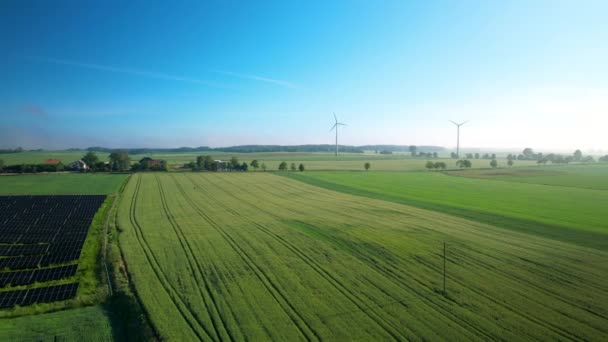 空中全景摄影 展示安装太阳能电池板农场和风车的农田 以获取清洁的绿色能源 — 图库视频影像