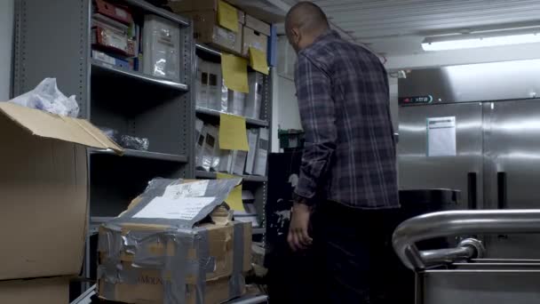 Bald Indian Male Searching Different Shelves Boxes Office Basement Locked — Stockvideo