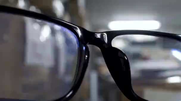 Close View Black Rim Glasses Bokeh Background Male Searching Shelves — Stock videók
