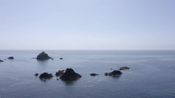 Ocean Aerial Flies Jagged Rocks Flat Blue Water Horizon — Vídeos de Stock