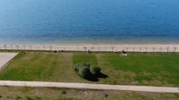 Lake Beach People Walking Sunbathing Bathing Lawn Garden Shrubs Overhead — Video