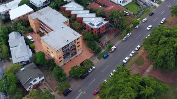 オーストラリアのQld ブリスベン市の道端に並んで駐車車両と現代の住宅ビル ドローン高角度ショット — ストック動画