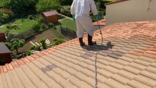 在具有防水涂料的房屋的防护服喷涂顶板的工人 高角度 — 图库视频影像
