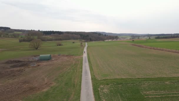 Approaching Motorbike Rider Viewed European Countryside Early Spring Static Wide — Stock video