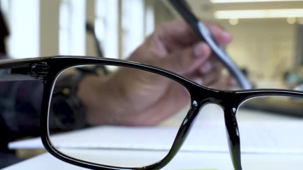 Blurred Left Hand Spinning Pen Seen Black Frame Eye Glasses — Stockvideo