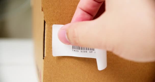 Χέρια Εφαρμόζοντας Ετικέτα Fragile Αυτοκόλλητο Ένα Κουτί Προϊόντος Από Χαρτόνι — Αρχείο Βίντεο