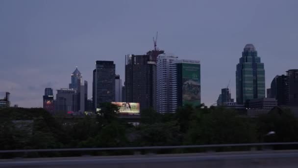 バンコクの高架道路沿いを都市中心部で運転高層ビル背景 バンコクブルーアワー バンコクスカイラインから遠く — ストック動画