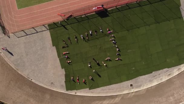 Kids Doing Situps Running Track Top Rotating Aerial — ストック動画