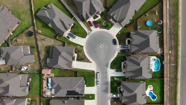 Top down aerial of rooftops of homes and swimming pools in modern American residential suburban community.