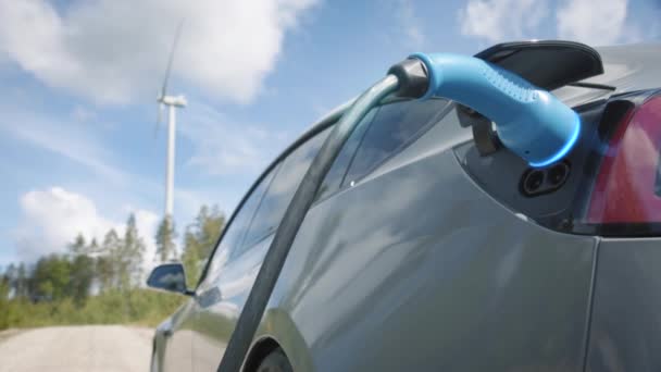 Zoom Graphics Enhanced Generic Electric Car Charges Front Wind Turbine — Videoclip de stoc