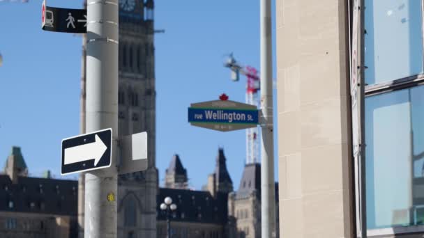 夏の晴れた日を背景にカナダ議会とオタワのダウンタウンでウェリントンストリートサイン 4Kスローモーション — ストック動画