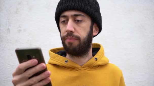 Bearded Handsome Man Gets Angry While Holding Smartphone Close — Vídeos de Stock