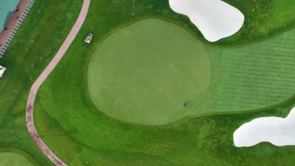高尔夫球场鸟瞰图 俱乐部附近的洞穴 一大早 一个工人在割草 照料着草坪 从上往下 — 图库视频影像