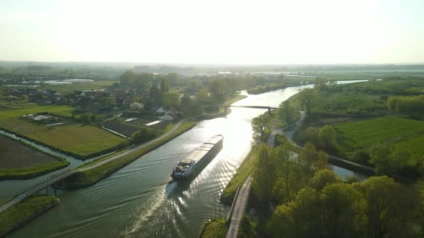 法国克拉玛雷附近一座桥下的一艘游艇落日时的空中景色 河的两边都有道路 左边有一个村庄 天空是白的 — 图库视频影像