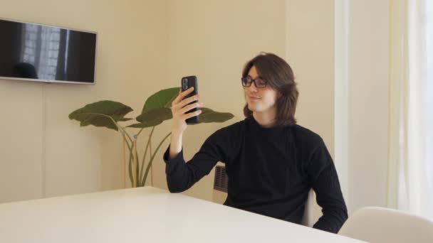 Young Man Glasses Video Call His Cell Phone Sitting Table — Stockvideo