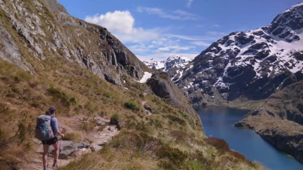 Pan Hiker Walks Alpine Lake Snow Capped Mountain Landscape Routeburn — Stock videók