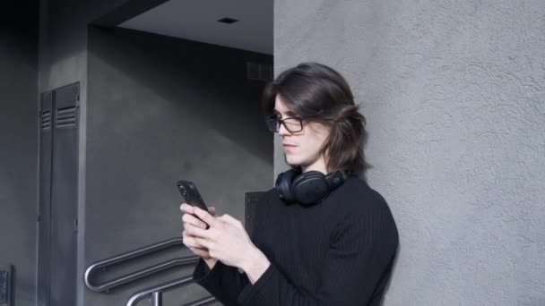 Young Man Glasses Headphones His Neck Texting His Cell Phone — Stockvideo