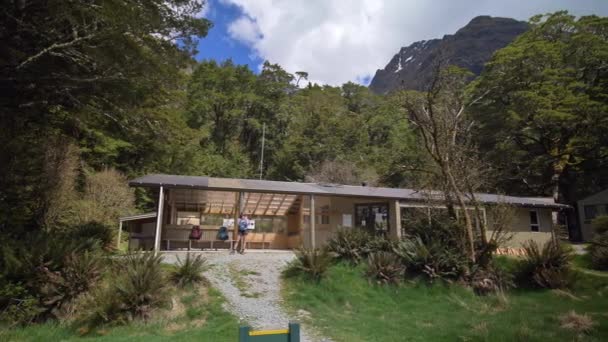 Pan Female Hiker Takes Photos Mountainous Landscape Routeburn Flats Hut — Vídeos de Stock