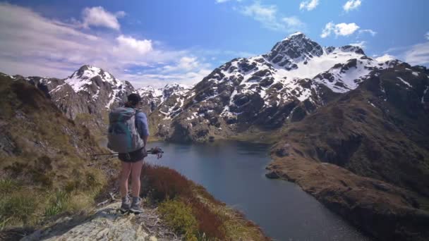 Pan Hiker Overlooks Alpine Lake Snow Capped Mountain Landscape Routeburn — Stockvideo