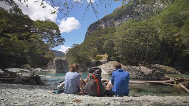 Static Hikers Eat Lunch Rocky Beach Overlooking Tranquil River Routeburn — Vídeo de stock