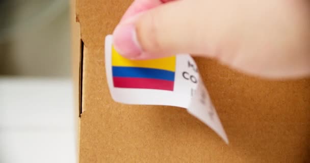 Hands Applying Made Colombia Flag Label Shipping Cardboard Box Products — Vídeos de Stock