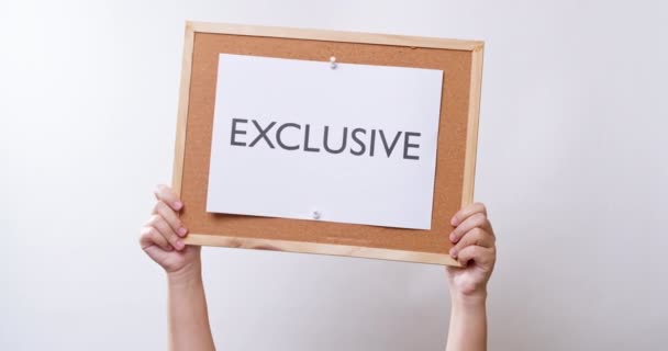 Woman Hand Shows Paper Board Word Exclusive White Studio Background — Vídeo de Stock