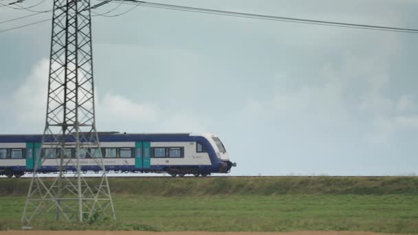 Train Passes Green Farm Fields Powerlines Foreground Slow Motion Pan — Vídeos de Stock