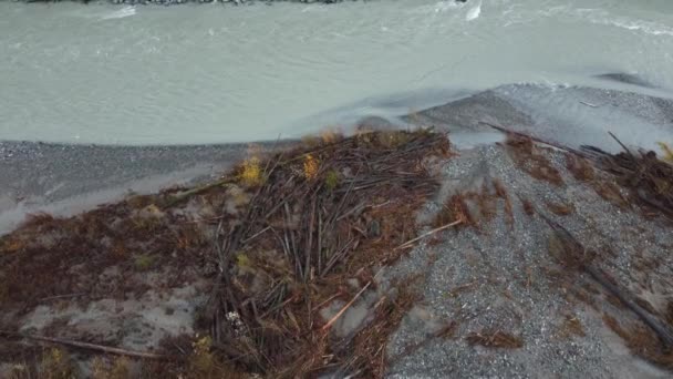 新鮮な流れる川に沿って実行されている山岳道路の衝突障壁を修復する航空機を示すクレーン 傾斜アップ — ストック動画