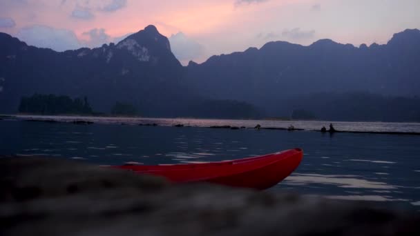 Red Empty Kayak Schwimmt Neben Cheow Lan Lake Bei Sonnenuntergang — Stockvideo