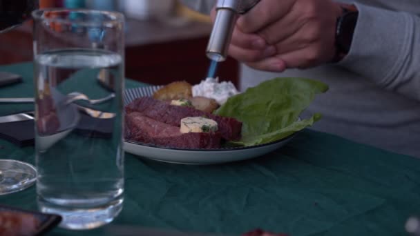 トーチからの火災屋外ディナーパーティーで牛肉のハーブバターを溶かす — ストック動画