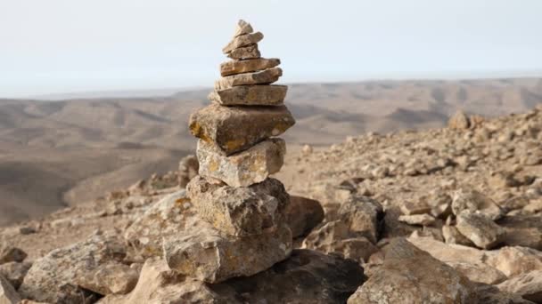 Tight Focus Conical Stone Cairn While Revealing Endless Barren Countryside — Vídeos de Stock