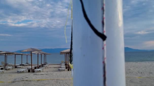 Beach Volleyball Net Sunbeds Straw Beach Umbrellas Close View — стоковое видео