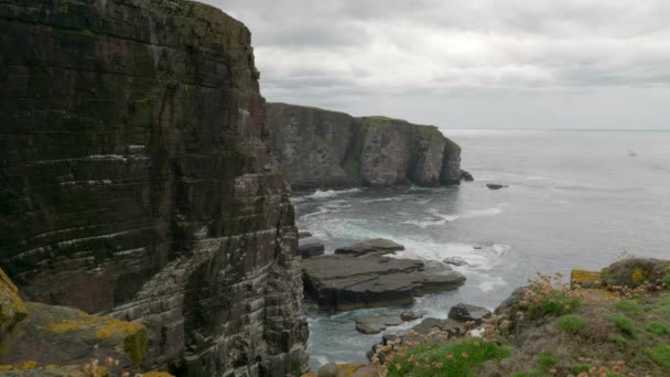 Waves Gently Crash Rocks Tall Imposing Sea Cliff Ocean While — стоковое видео