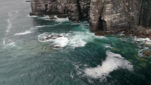 Waves Gently Crash Rocks Tall Imposing Sea Cliff Deep Teal — Vídeo de stock