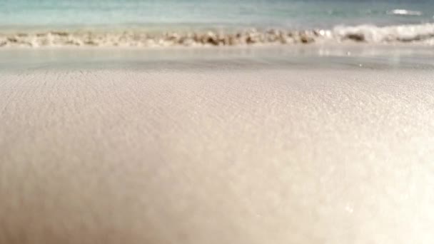 大西洋のターコイズブルーの波は カメラが非常に浅いフィールドの深さで地面のレベルに座っているので キラキラした砂に優しく重なります スコットランドの半田島 — ストック動画