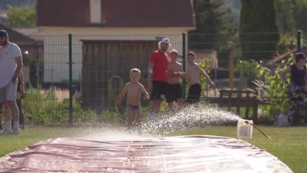 Niño Feliz Tobogán Acuático Para Refrescarse Día Caliente Durante Evento — Vídeos de Stock