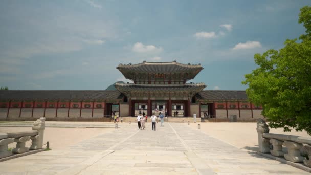 Tourists Protective Masks Sightseeing Geunjeongmun Gate Gyeongbokgung Palace Clear Sky — Vídeos de Stock