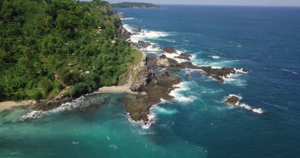 在蓝色的海洋边 有绿树和种植园的空中海岸线滑行的无人驾驶飞机镜头 有珊瑚礁被海浪击中 印度尼西亚Pengilon Hill — 图库视频影像