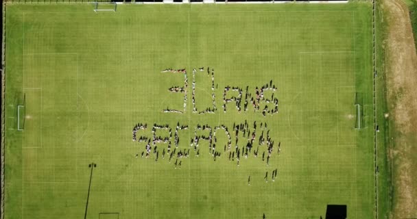 People Forming Ans Grassy Field 30Th Year Anniversary Sports Association — Stock video