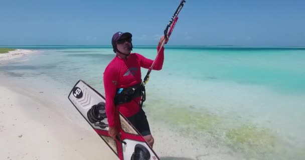 男Kitesurf白い砂浜で教えるためのマイクとヘッドセットを使用します コントロールバーを保持します — ストック動画