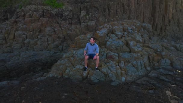 Man Sitting Rocks Cathedral Rocks Kiama Sunrise Zoom Out Fly — Stok video