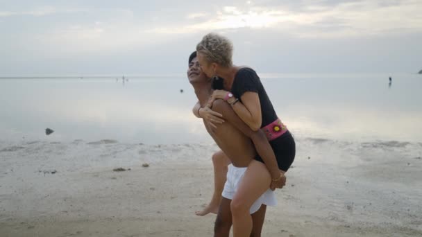 Lovely Interracial Couple Piggyback Ride Kissing Beach Sunset — Stockvideo