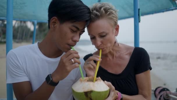 Pareja Interracial Con Diferencias Edad Beber Agua Coco Través Una — Vídeos de Stock