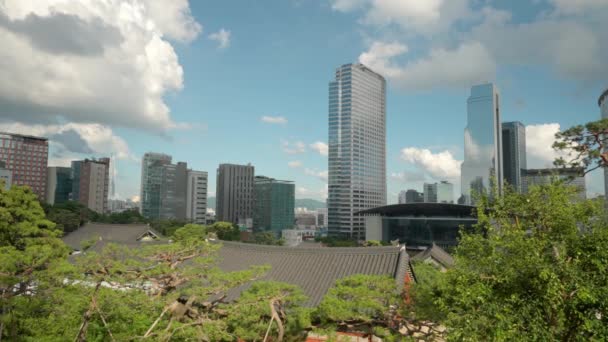 ソウルのダウンタウンのスカイライン アセムタワーの建物の外観とWtcソウル貿易タワーとコックスの上の雲前に緑の木と奉恩寺タイルの建物のコンベンションと屋根 — ストック動画