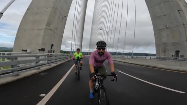 Two Cyclists Riding Bridge Male Caucasian Wearing Pink Lycra Helmet — Vídeos de Stock