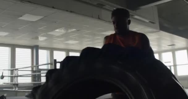 Молодой Черный Мужчина Делает Тяжелые Упражнения Спортзале Бросая Тяжелые Шины — стоковое видео