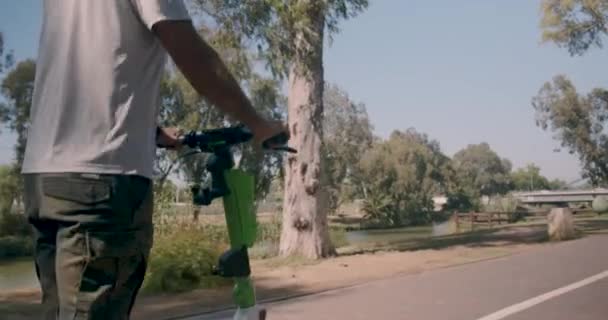 Hombre Montando Scooter Eléctrico Los Suburbios Una Ciudad Mientras Usa — Vídeos de Stock