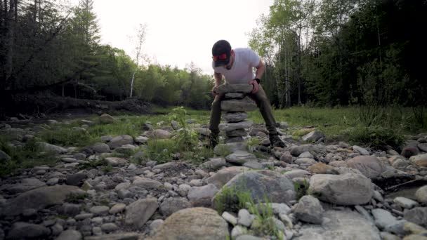 Frustrated Male Hiker Balances Large Pile Jagged Stones Scattered Rocks — Stockvideo