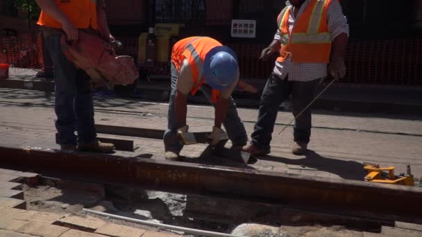 工人们排起一根钢梁 让另一个工人用他的锯子慢动作地锯断 — 图库视频影像