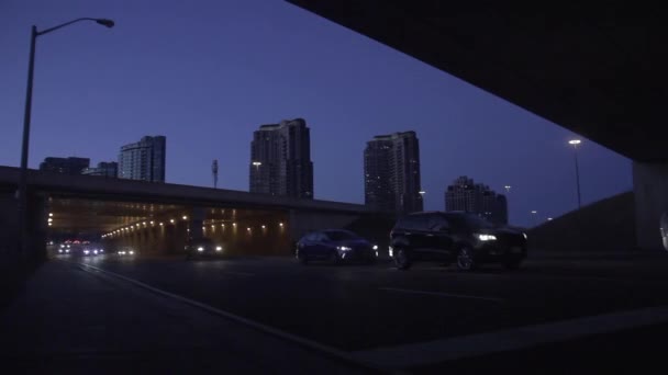 Cars Driving Tunnel Night Tall Towering Buildings Lights Background Timelapse — Video